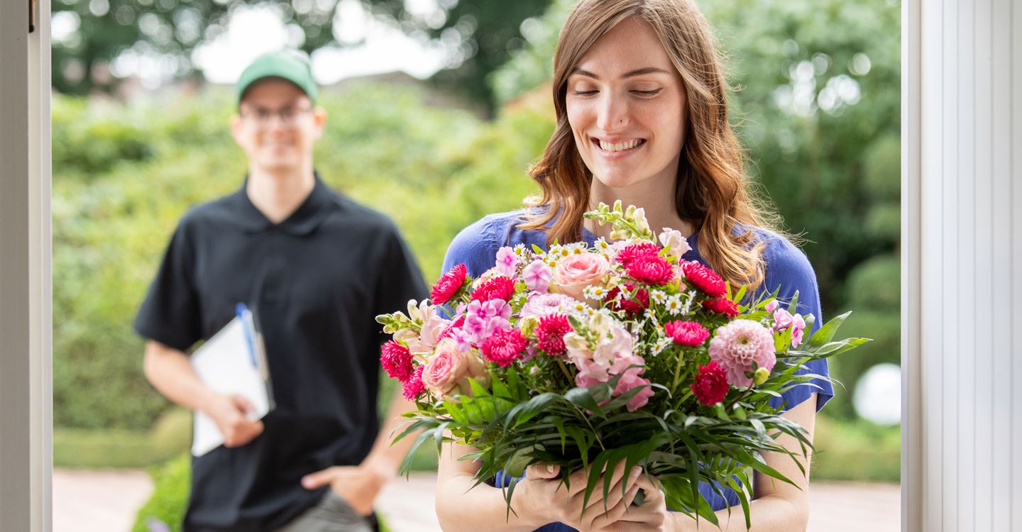 Lieferservice - Frau erhält Blumenpräsent